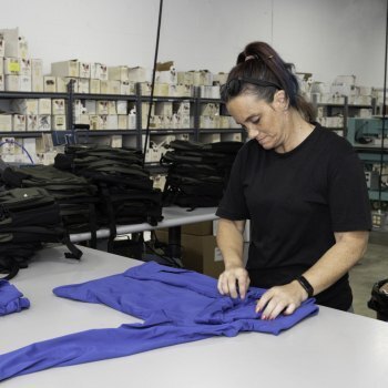 a woman folding a blue jacket